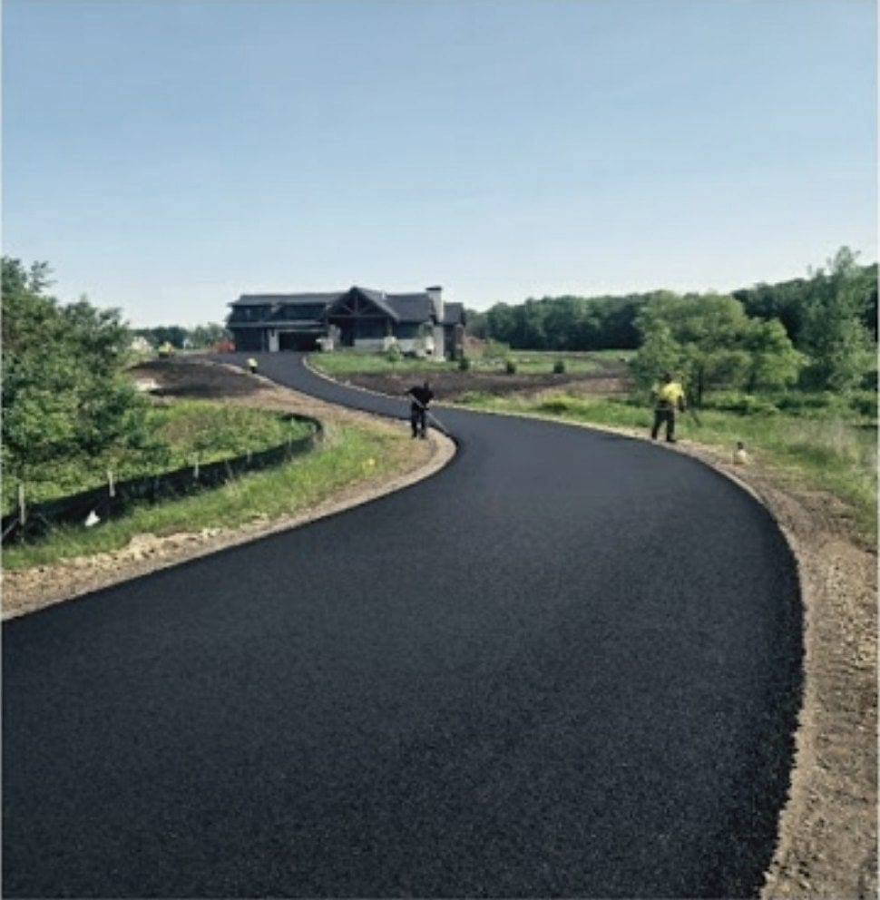 A new drive sweeping in a long curve across open ground to the house, fresh shoulder either side.
